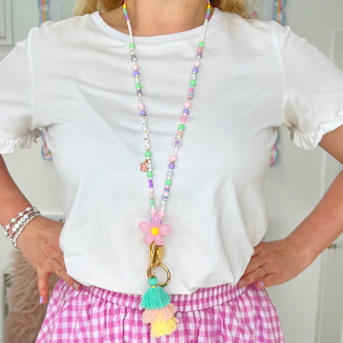 Primary school teacher wearing pastel beaded lanyard in classroom setting