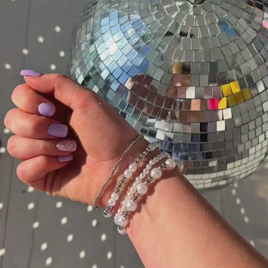5-second product video showing silver bracelet stack sparkling in classroom light