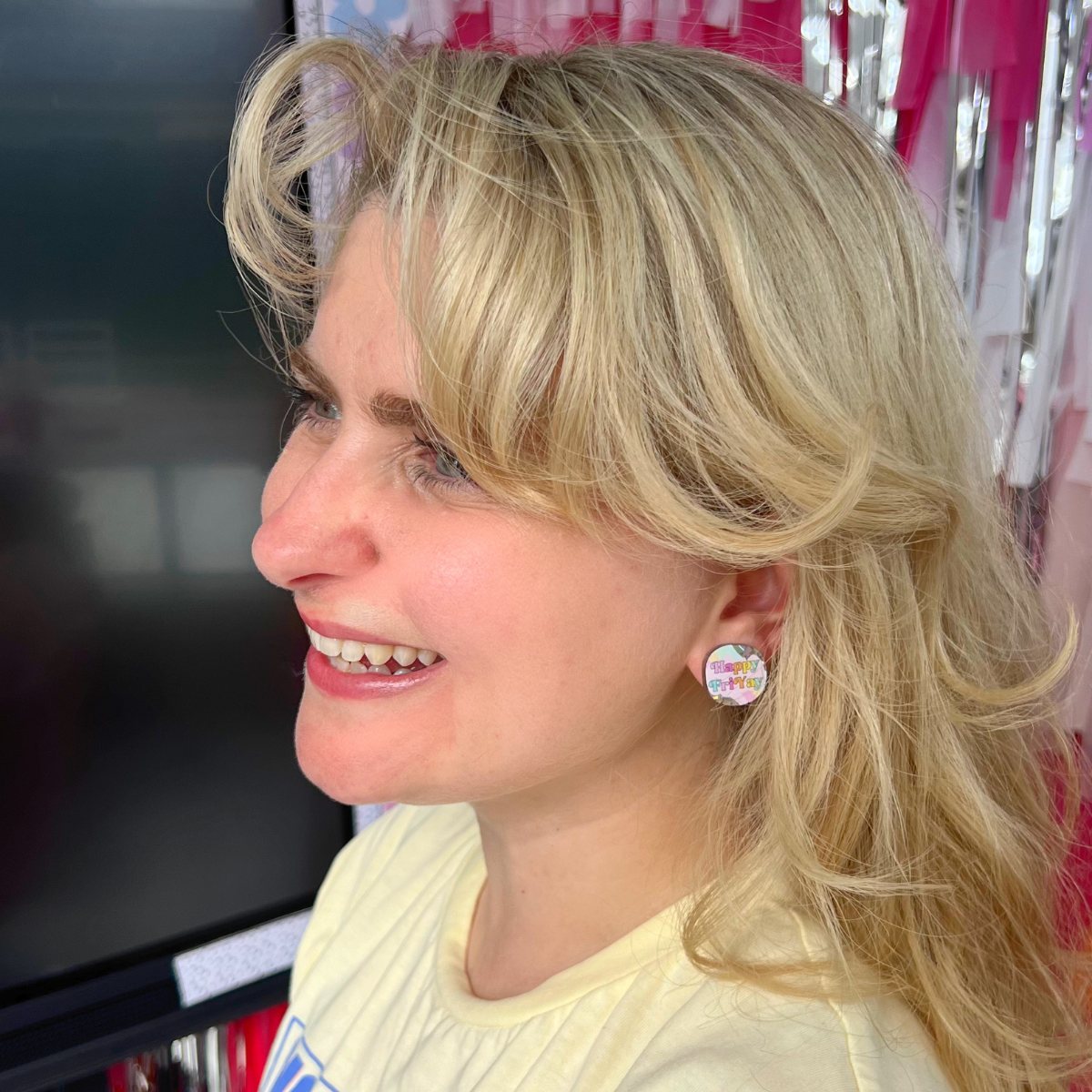 Teacher wearing Happy FriYAY rainbow sparkle acrylic stud earrings in classroom – Educator Bling handmade accessory.